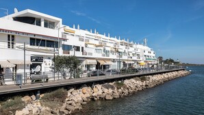 A waterfront building with multiple floors, balconies, and a restaurant named SABORES DA RIA.