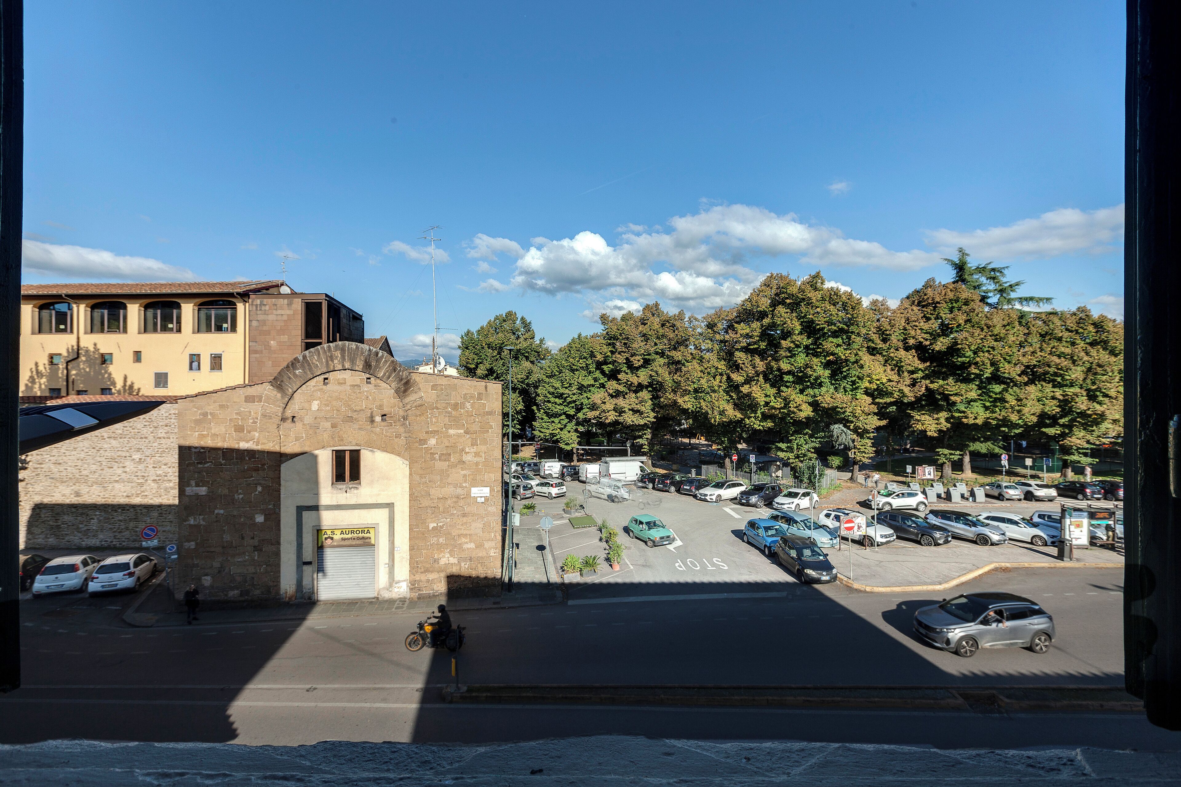 A parking lot with cars and a building with a sign reading "A.S. AURORA".