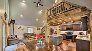 Un espacio habitable amplio con una mesa de comedor de madera, un sofá y una chimenea.