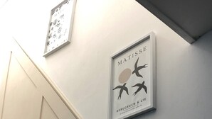 A wall with framed artwork, including a piece by Matisse and another with abstract patterns.