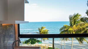 A modern bathroom with a large window overlooking a beach and ocean. - Kauai Beach Residence (Tamandaré)