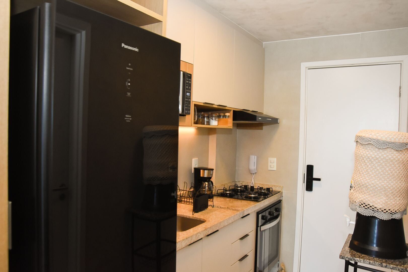 Een kleine keuken met een koelkast, fornuis en magnetron.