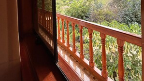 A wooden balcony with a view of a mountainous landscape. - Sara Garden Lodge (Ollantaytambo)