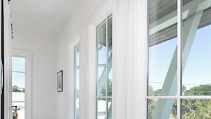 Interior moderno com grandes janelas, uma escadaria e vista para o exterior.