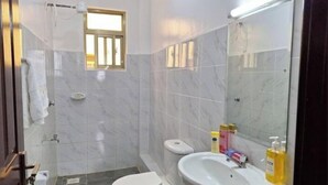 A bathroom with a toilet, sink, and shower.