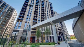 A modern high-rise building with multiple balconies and a covered walkway. - The Robinson (Wembley)