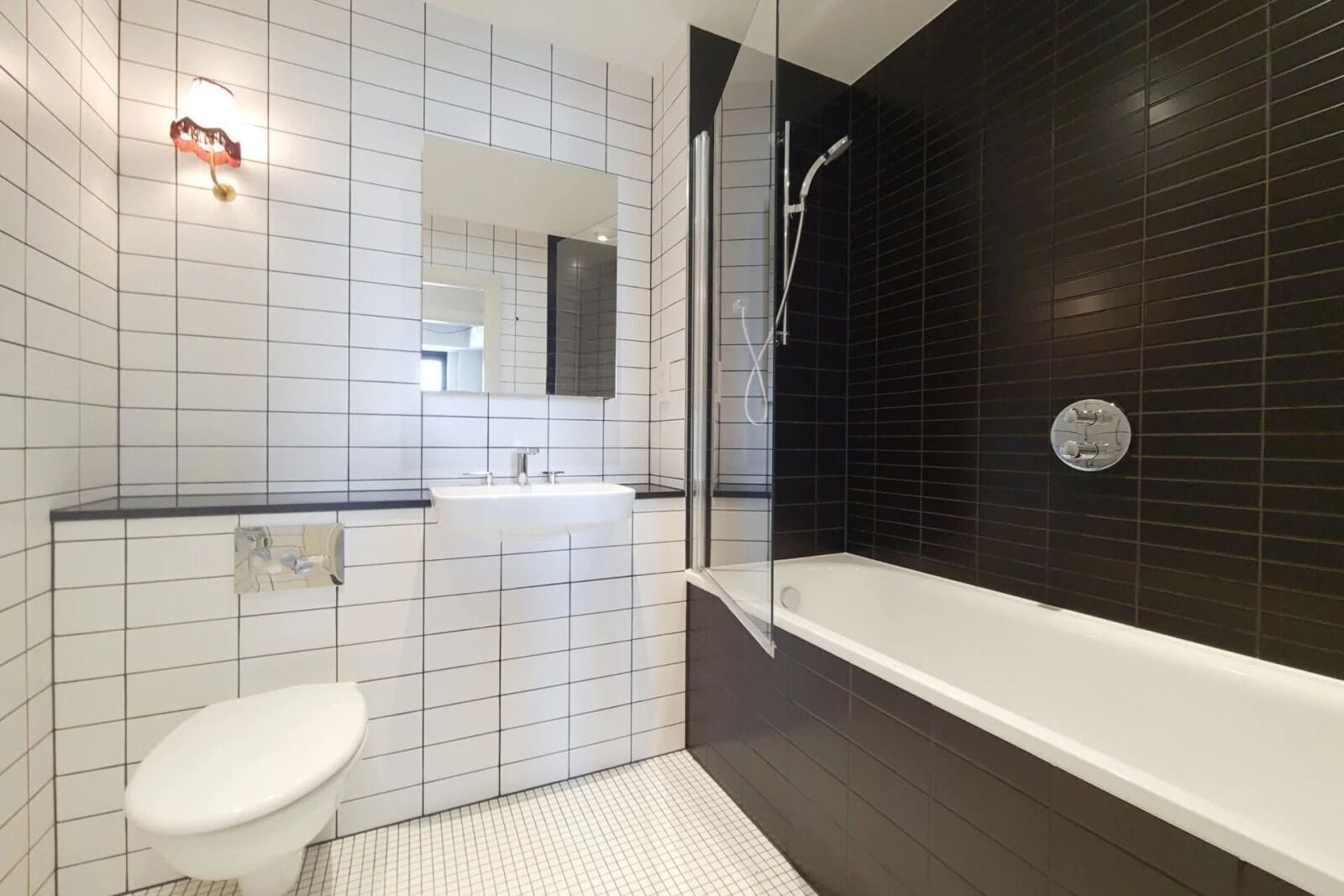 A modern bathroom with a toilet, sink, and shower.