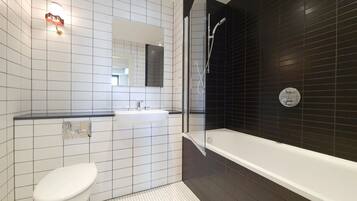 A modern bathroom with a toilet, sink, and shower.