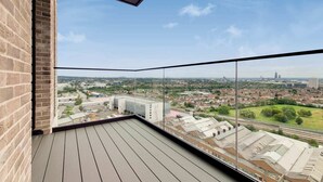 A balcony with a clear view of a cityscape, including buildings and a highway. - The Robinson (Wembley)