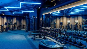 A gym with various exercise equipment, including treadmills, stationary bikes, and weight machines. - The Robinson (Wembley)