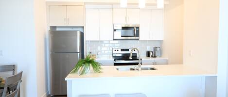 Fridge, stovetop, dishwasher, coffee/tea maker