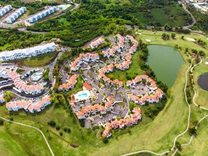 An aerial view of a residential area with a golf course, a swimming pool, and a lake. - Rio Grande Rio Mar cluster 2,Vista Del Mar- View (Río Grande)