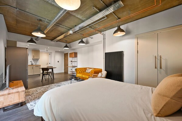 Une chambre d’hôtel moderne, dotée d’un grand lit, d’un canapé et d’un coin repas.