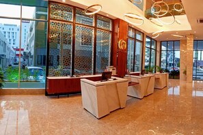 A hotel lobby with a reception desk, seating area, and large windows. - Grand Flora Hotel (Melaka)
