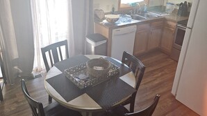 A compact kitchen with a dining area, wooden cabinets, a built-in oven, and a ceiling fan. - Charming 2-bedroom condo with WiFi, AC in delightful Canton (Canton)