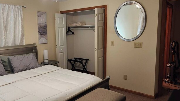 A bedroom with a bed, a bedside table, a mirror, a closet, and a bathroom. - Charming 2-bedroom condo with WiFi, AC in delightful Canton (Canton)