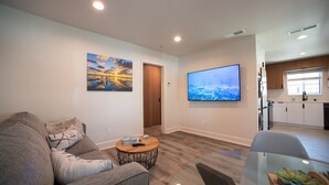 A modern living room with a sofa, coffee table, and artwork on the walls.