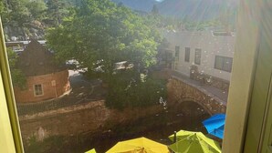 A view from a window overlooking a street with trees and buildings. There are umbrellas visible in the foreground. - Manitou Incline Retreat

 (Manitou Springs)