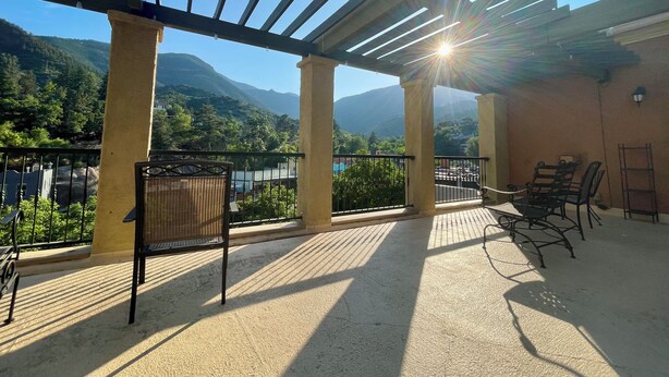 A covered outdoor area with a pergola, seating, and a view of mountains. - Manitou Incline Retreat

 (Manitou Springs)