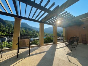 A covered outdoor area with a pergola, seating, and a view of mountains. - Manitou Incline Retreat
(Manitou Springs)