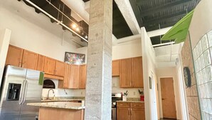 A modern kitchen with exposed concrete pillars, stainless steel appliances, and wooden cabinets. - Manitou Incline Retreat

 (Manitou Springs)