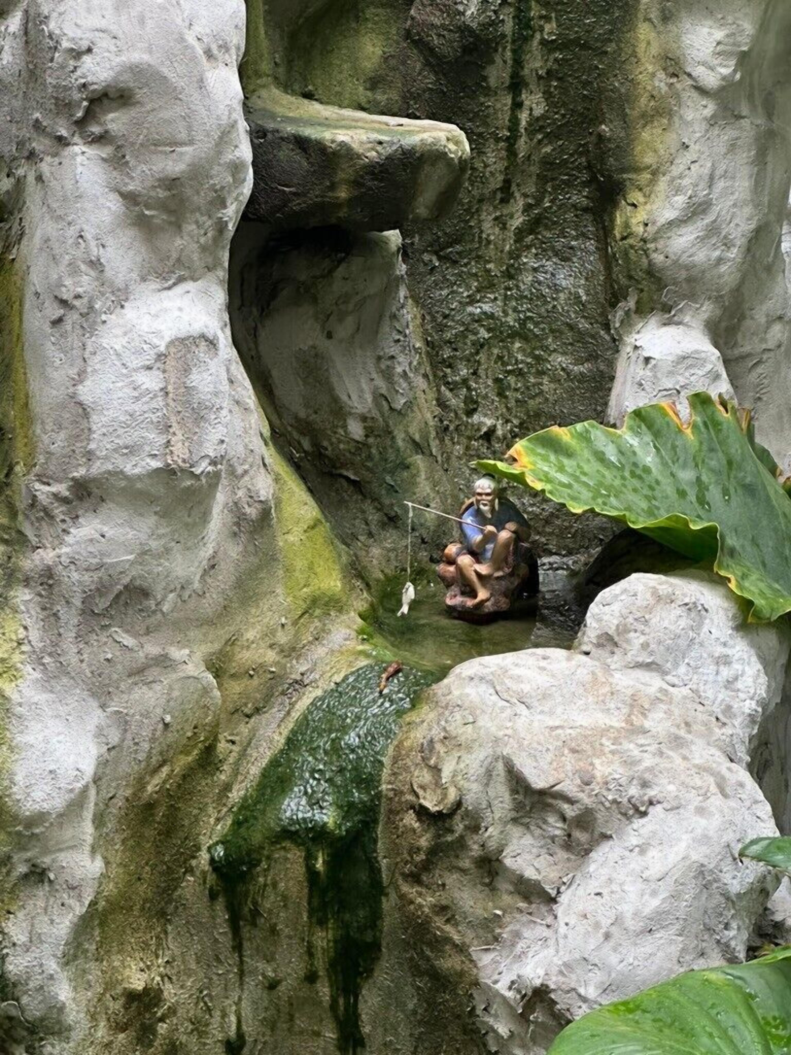 Un espacio estrecho parecido a una cueva, con paredes rocosas y un pequeño charco de agua.