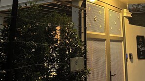 Ένα σύγχρονο κτίριο με μια μοναδική τριγωνική στέγη, μια πύλη στην είσοδο και μια πινακίδα που υποδεικνύει ότι είναι ο αριθμός 1.