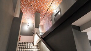 A staircase with patterned tiles and a geometric design. - Calma Rooms by Charming (Madrid)