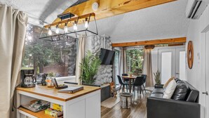 A compact living space with a kitchenette, a dining area, and a seating area with a sofa.