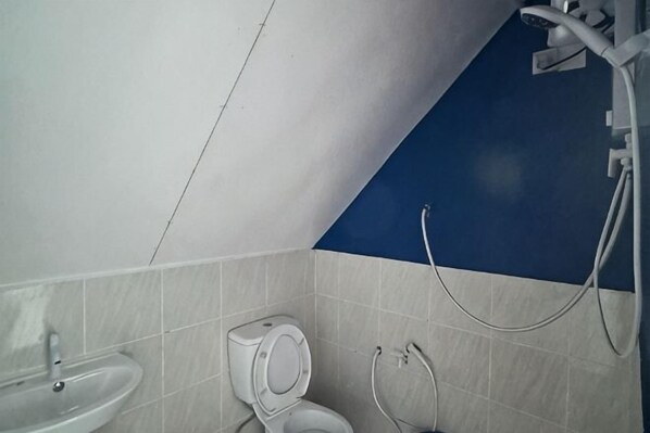 A bathroom with a toilet, sink, and shower. - Adil Waterhouse Resort (Semporna)
