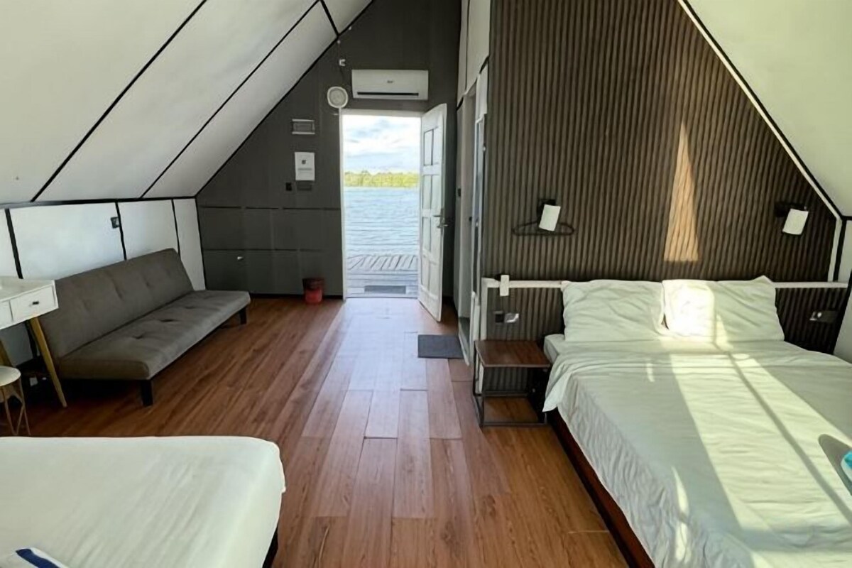 A modern bedroom with a bed, a sofa, and a desk.