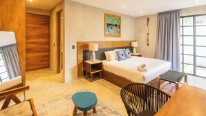 A modern hotel room with a large bed, two bedside tables, a desk, a chair, and a window with curtains. - Privé Turquoise  (Tulum)