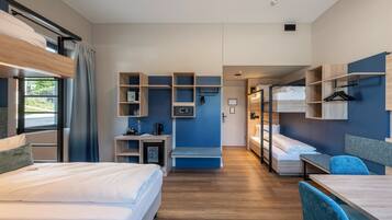A modern hotel room with bunk beds, a desk, and built-in shelving.