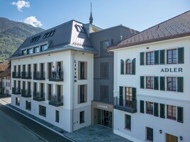 Un edificio moderno con balcones y un escaparate que dice 'LIVINN'.