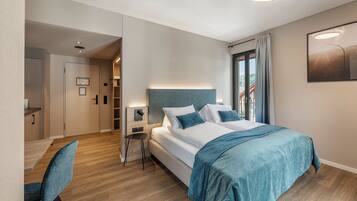 Et moderne hotelværelse med en stor seng, et skrivebord og en stol. Der er udsigt til det fri gennem vinduet.