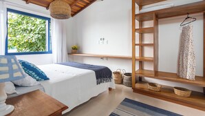 A bedroom with a bed, a hanging basket, a shelf with a dress, and a window with greenery outside. - House in Búzios less than 100m from the beach (Vila Luiza Armação dos Búzios)