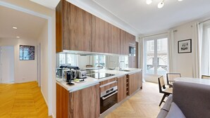 Eine moderne Küche mit Holzschränken, einem eingebauten Backofen und einem großen Fenster.