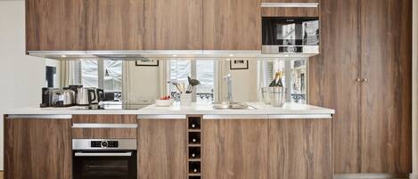 A modern kitchen with wooden cabinetry, a Bosch microwave, and a built-in oven.