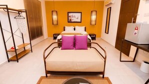 A hotel room with a bed, bedside tables, a wardrobe, a desk with a chair, and a hanging clothes rack. - Rebungan Resort Langkawi (Langkawi)
