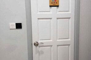 Une porte blanche avec un sonnette et une pancarte au-dessus.
