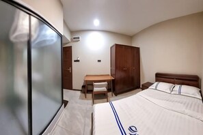 A bedroom with a bed, a desk, and a wardrobe. - Global Residency (Kota Kinabalu)
