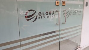 En glasdörr med logotypen ”GLOBAL RESIDENCE” och ett handtag i metall.
