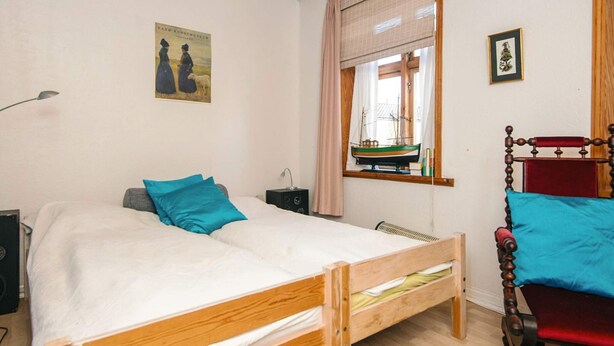 A bedroom with a wooden bed, a nightstand, a lamp, a window with a view of a boat, and a small ship model. - Captain House BnB in Fano (Fano)