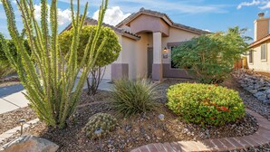 A residential house with a landscaped garden featuring various plants and a paved driveway. - Serene Vacation Home - Trails, Golf & Dining! (Marana)