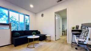 Una sala de estar moderna con un sofá, una mesita redonda y un escritorio con una silla.