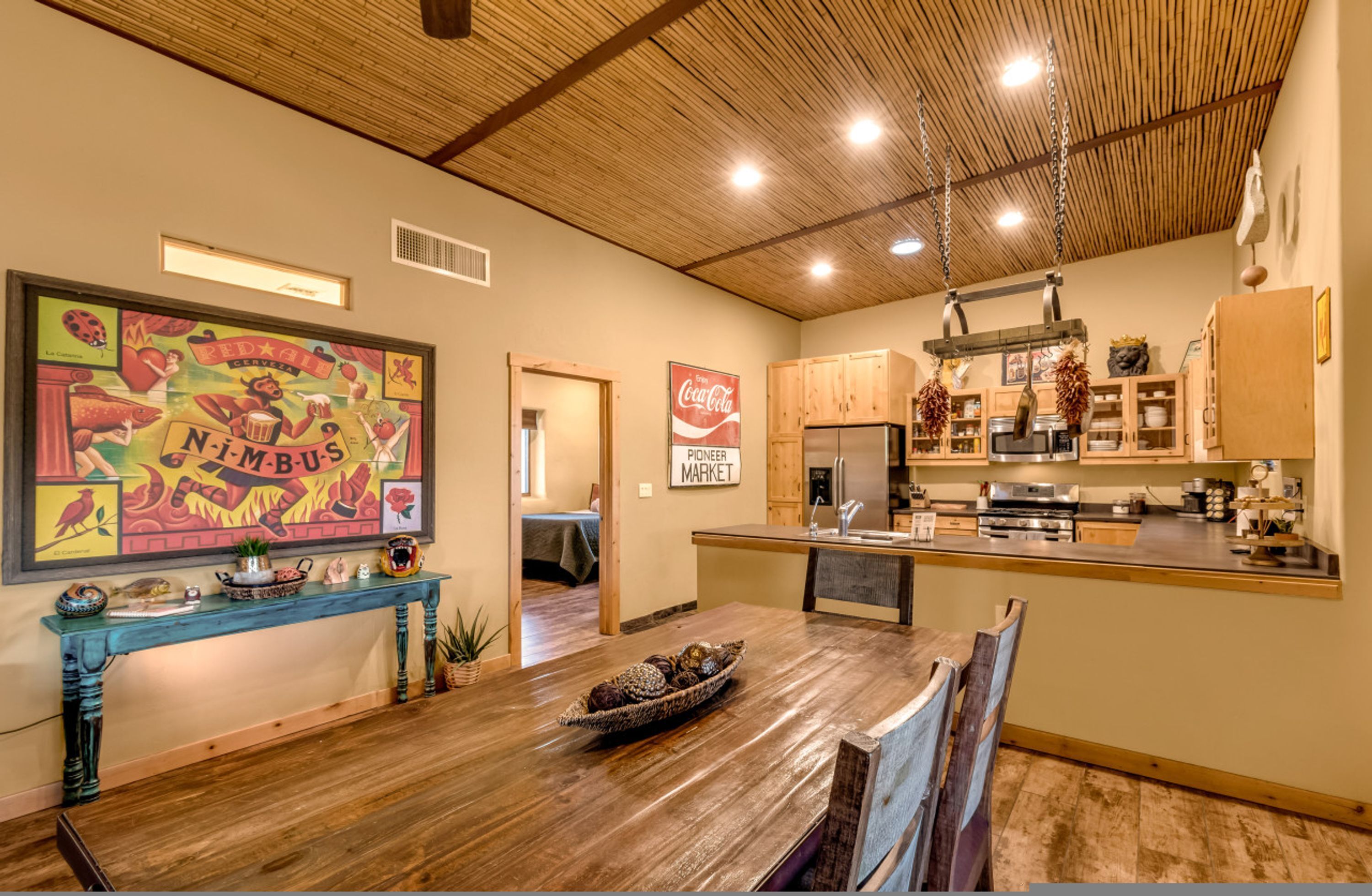 A spacious kitchen with wooden cabinets, a central island, and a dining area with a wooden table and chairs.