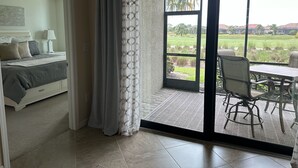 Een slaapkamer met een bed, nachtkastje en plafondventilator.