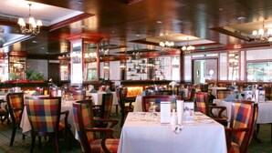 A restaurant with multiple tables and chairs, some with plaid upholstery. - Imperial Hotel Miri (Miri)