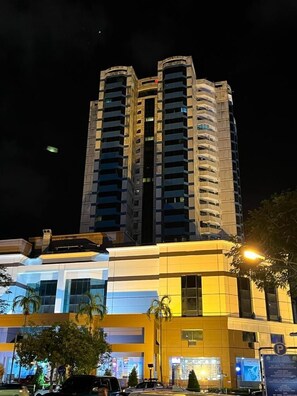 A high-rise building with multiple balconies, a parking area, and a well-lit entrance. - Imperial Hotel Miri (Miri)