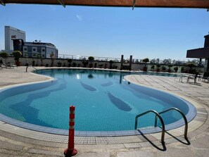 A swimming pool with a tiled deck, a safety cone, and a metal handrail. - Imperial Hotel Miri (Miri)